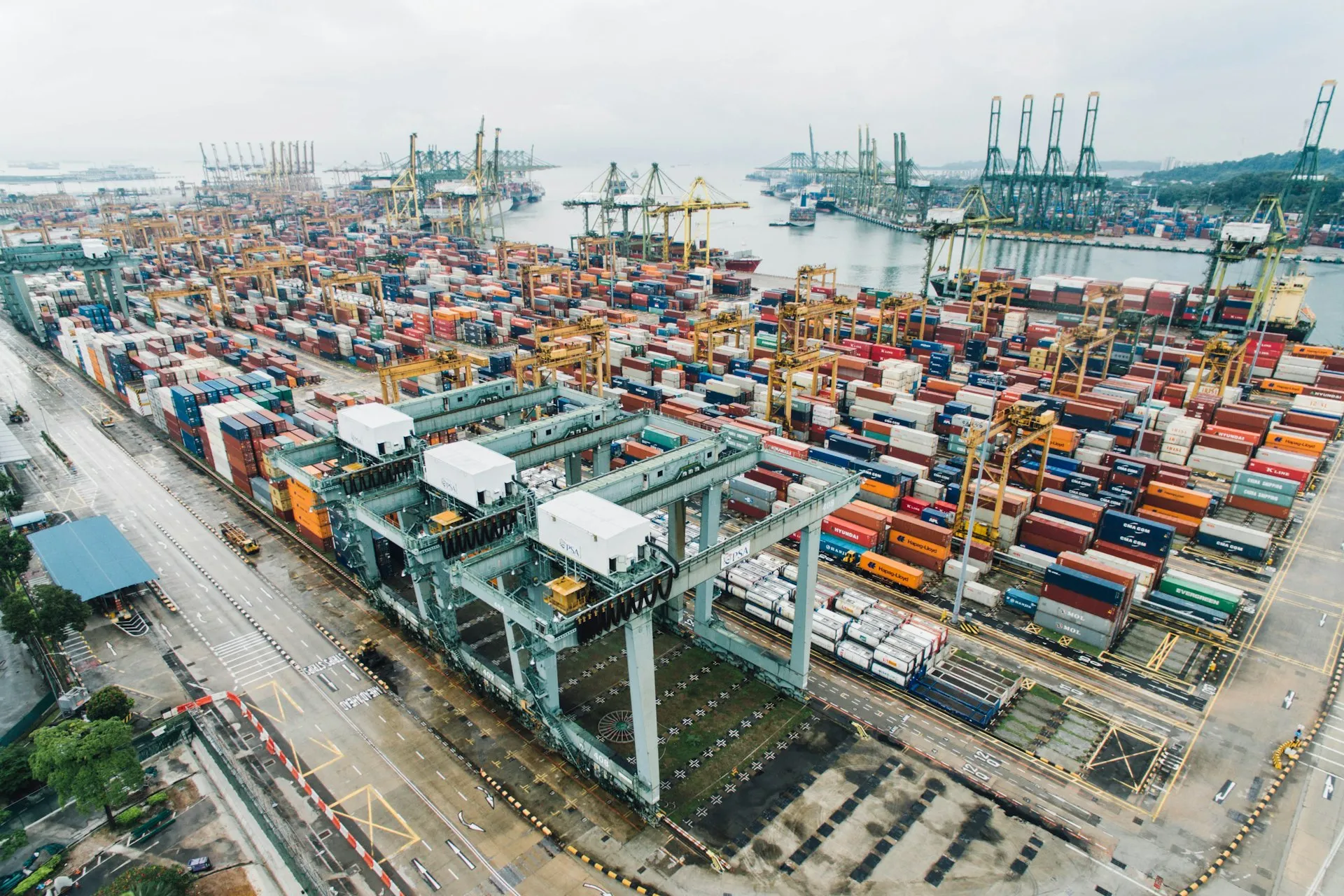 An aerial view of a shipping port with stacked containers